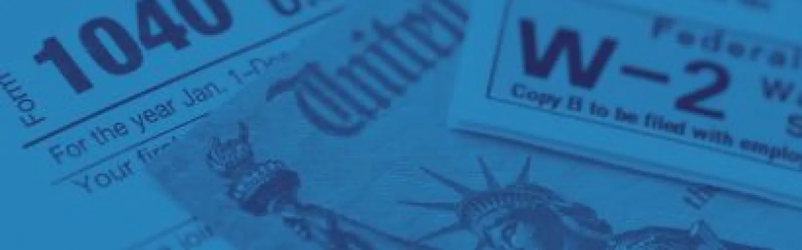 a 1040 form and W-2 form sit on a desk